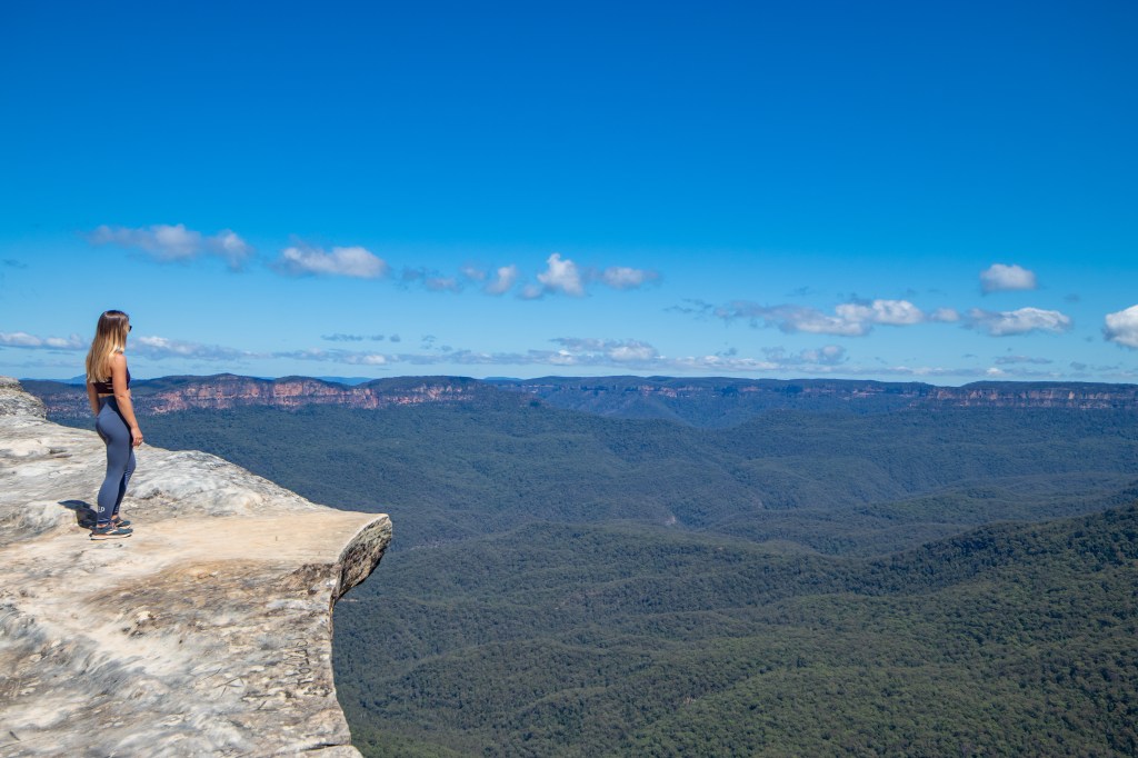 Sarah standing on the white lincolns rock looking into the green jamison valley in the distance