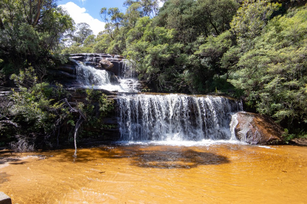 Cascading water flowing over two different edges into a pool.