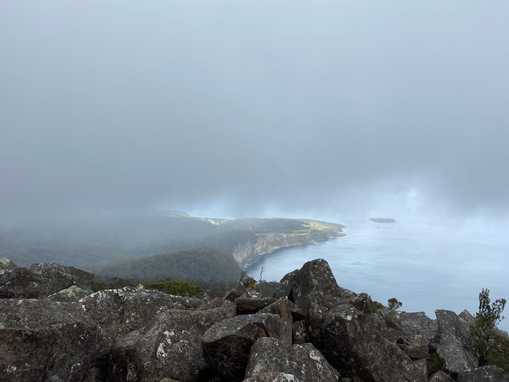 A dark grey rain cloud lowering over the view from the summit.