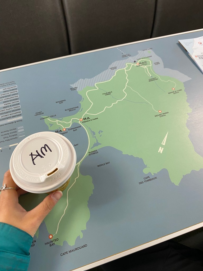 A almond milk coffee cup on top of the Maria Island map.